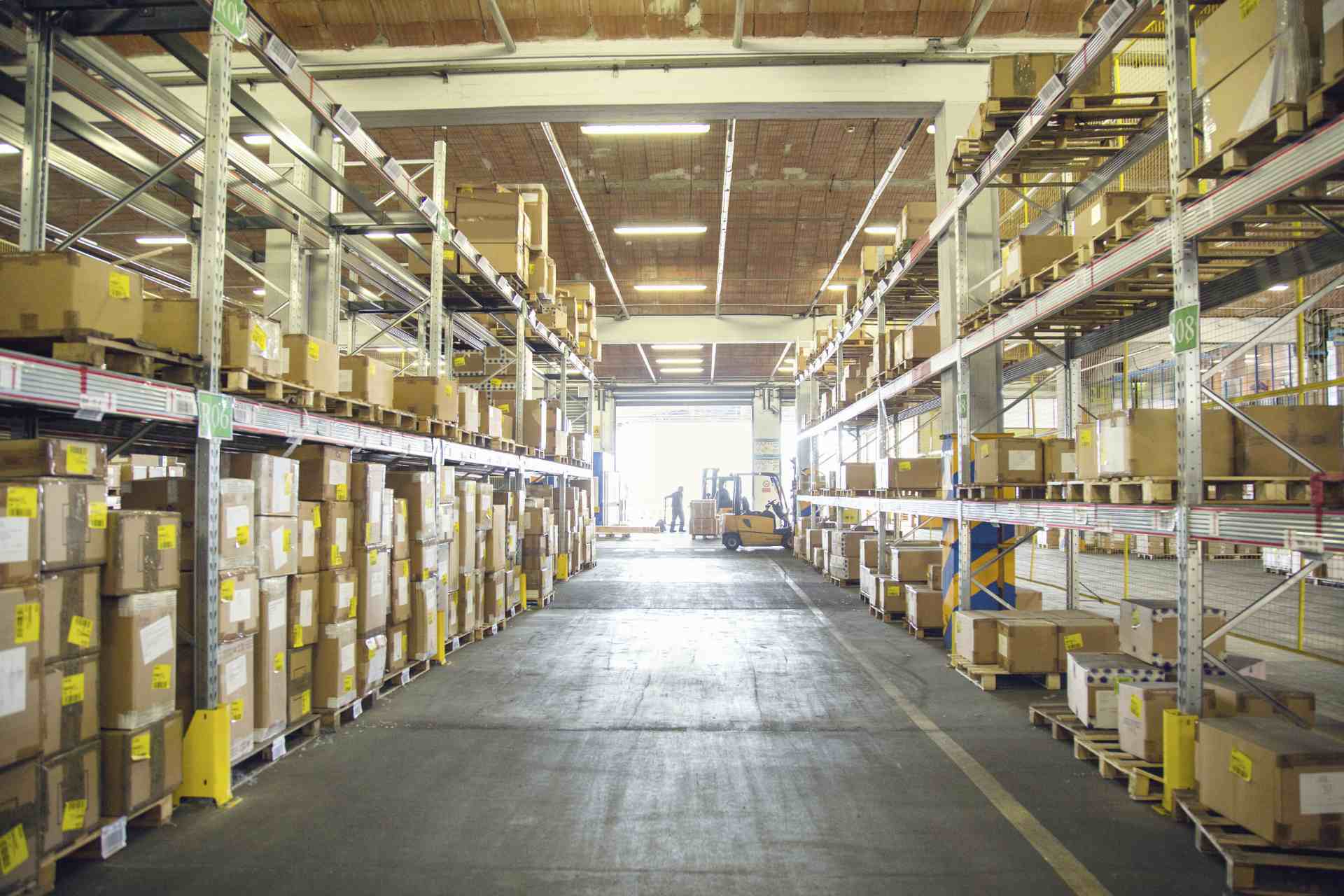 Forklift trucks and drivers working in distribution warehouse ai